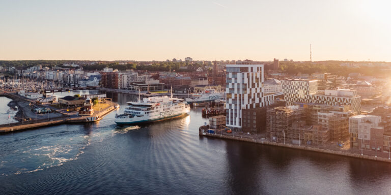 Vy hamninlopp inrehamnen. Färjor, hamn och stadsmiljo, hav, solnedgång.